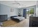 A blue-walled bedroom with a sliding glass door, ceiling fan, and wood-look flooring at 607 Greencastle Dr, Goose Creek, SC 29445