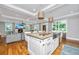Open concept kitchen and living room showcasing a spacious island, modern lighting, and seamless transition between spaces at 619 Thomas Glenn Ct, Charleston, SC 29412