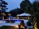 Backyard pool and patio with lounge chairs and ambient lighting for relaxing and entertaining at 619 Thomas Glenn Ct, Charleston, SC 29412