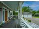 Inviting front porch with comfortable seating, a decorative door, and a view of the detached garage at 619 Thomas Glenn Ct, Charleston, SC 29412