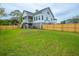 A spacious fenced-in backyard with lush green grass and a playset on a sunny day at 637 Lynne Ave, Charleston, SC 29412