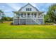 Inviting two-story home with a classic design, elevated porch and well-kept lawn at 637 Lynne Ave, Charleston, SC 29412