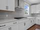 Well-lit kitchen with stainless steel range hood, cooktop, light grey backsplash, and white countertops at 637 Lynne Ave, Charleston, SC 29412