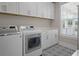 Well-lit laundry room with matching washer and dryer and white cabinets at 637 Lynne Ave, Charleston, SC 29412