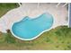 Aerial view of sparkling pool with a tanning ledge, surrounded by a travertine patio and lush green grass at 703 Blueway Ave, Summerville, SC 29486
