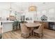 Open-concept kitchen and dining area featuring modern lighting, stainless appliances, and ample seating at 703 Blueway Ave, Summerville, SC 29486