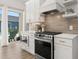 Well-equipped kitchen featuring modern appliances, tile backsplash, and a sliding door to an outdoor area with a pool view at 703 Blueway Ave, Summerville, SC 29486