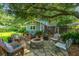 Outdoor living space with comfortable seating around a stone fire pit and lush landscaping at 802 Robert E. Lee Blvd, Charleston, SC 29412