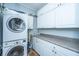 Bright laundry area featuring a stacked washer and dryer and sleek white cabinetry and countertops at 802 Robert E. Lee Blvd, Charleston, SC 29412