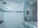 Beautiful shower design with subway tile, blue accent stripe and sleek glass partition at 802 Robert E. Lee Blvd, Charleston, SC 29412