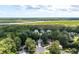 Aerial view of a home nestled among trees with a marsh view in the background at 8320 Tyrian Path, North Charleston, SC 29418