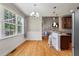 Well-lit dining area with hardwood floors, large windows, and connection to the kitchen and living spaces at 8320 Tyrian Path, North Charleston, SC 29418