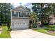 A charming two-story home with a well-manicured lawn, palm trees, and an attached two-car garage at 8320 Tyrian Path, North Charleston, SC 29418