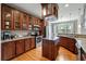 Well-equipped kitchen with stainless steel appliances, wood cabinetry, granite countertops, and an island at 8320 Tyrian Path, North Charleston, SC 29418