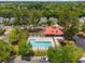 Aerial view of the community pool with lounge chairs and a clubhouse with a red roof surrounded by mature trees at 907 High Nest Ln, Charleston, SC 29412