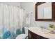 Bright bathroom with a classic wood-trimmed mirror, elegant vanity and patterned shower curtain at 907 High Nest Ln, Charleston, SC 29412