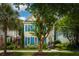 Inviting two-story home featuring yellow siding, blue shutters, and lush trees in a verdant lawn at 907 High Nest Ln, Charleston, SC 29412
