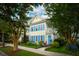 Charming two-story home with yellow siding, blue shutters, and a beautifully landscaped front yard at 907 High Nest Ln, Charleston, SC 29412