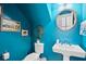 Stylish powder room with unique blue walls, round mirror, and a pedestal sink at 907 High Nest Ln, Charleston, SC 29412