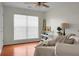 Bright bedroom with a large window, wooden floor, ceiling fan and bedside decor at 9255 Ayscough Rd, Summerville, SC 29485