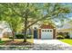 Charming brick home featuring mature landscaping, a well-manicured lawn, and a driveway leading to an attached garage at 9255 Ayscough Rd, Summerville, SC 29485