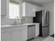 A modern kitchen with white cabinets, stainless steel appliances, and bright natural light at 9255 Ayscough Rd, Summerville, SC 29485