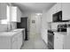 A well-lit galley kitchen with white cabinets and modern stainless steel appliances at 9255 Ayscough Rd, Summerville, SC 29485
