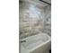 Bathroom with white jacuzzi tub and marble tile surround with nickel finish faucet at 963 Yorktown Dr, Charleston, SC 29412