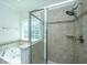 Bathroom with a large, tiled walk-in shower and a soaking tub beneath a bright window at 9710 Table Mountain Ln, Ladson, SC 29456