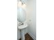 Powder room with a stylish pedestal sink, round mirror, and wood flooring at 9710 Table Mountain Ln, Ladson, SC 29456
