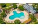 An aerial shot showcases the community pool, lounge chairs, a clubhouse, and greenery perfect for relaxing at 9710 Table Mountain Ln, Ladson, SC 29456