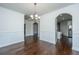 Open-concept dining area with hardwood floors, wainscoting, chandelier, and seamless flow to the kitchen at 9710 Table Mountain Ln, Ladson, SC 29456