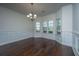 Elegant dining room showcasing hardwood floors, wainscoting, bay windows, and a chandelier at 9710 Table Mountain Ln, Ladson, SC 29456