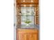 Wet bar with wood cabinets, granite countertop, and glass shelves for beverages and barware at 1 King St # 209 & 210, Charleston, SC 29401