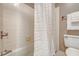 Cozy bathroom featuring white tiles, a shower with a curtain, and essential fixtures at 1 King St # 209 & 210, Charleston, SC 29401