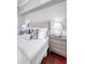 This cozy bedroom offers a tufted headboard and stylish bedside tables with lamps on hardwood floors at 1 King St # 209 & 210, Charleston, SC 29401