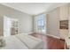 Bright bedroom featuring hardwood floors, a large window with shutters, and built-in shelving and cabinetry at 1 King St # 209 & 210, Charleston, SC 29401