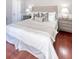 This bedroom offers a calming retreat with a tufted headboard and stylish bedside tables on hardwood floors at 1 King St # 209 & 210, Charleston, SC 29401