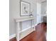 This home hallway with a Heron print, table, and hardwood floors provides warm welcome at 1 King St # 209 & 210, Charleston, SC 29401
