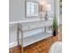 Hallway view featuring stylish console table with decor and warm lighting and beautiful hardwood floors at 1 King St # 209 & 210, Charleston, SC 29401