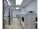 Well-lit laundry room with multiple rows of modern, front-loading washing machines at 1 King St # 209 & 210, Charleston, SC 29401