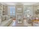 This living room has beautiful built-in shelves, a fireplace, and large windows overlooking the water at 1 King St # 209 & 210, Charleston, SC 29401
