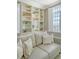 Living room featuring a comfortable couch, decorative pillows, built-in shelves, and window with plantation shutters at 1 King St # 209 & 210, Charleston, SC 29401