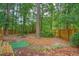 Private backyard featuring a wooden fence, mature trees, and a cozy fire pit area at 100 Dacs Ln, Summerville, SC 29483
