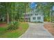 Charming two-story home with a well-manicured lawn, mature trees, and a long driveway at 100 Dacs Ln, Summerville, SC 29483