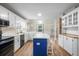 Open kitchen with white cabinets, a blue island, and a view into the dining area at 100 Dacs Ln, Summerville, SC 29483