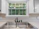 Close-up of the kitchen sink, with a view to the green backyard through the window at 100 Dacs Ln, Summerville, SC 29483