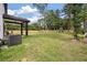 Expansive fenced backyard featuring a covered patio, lush lawn, and mature trees for outdoor enjoyment at 1000 Retreat Ave, Moncks Corner, SC 29461