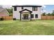 The white two-story home with black trim has an outdoor seating area in the fenced backyard at 1000 Retreat Ave, Moncks Corner, SC 29461