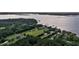 Aerial view of a waterfront property with a long private drive, surrounded by lush trees and a serene water view at 1085 Harts Bluff Rd, Wadmalaw Island, SC 29487
